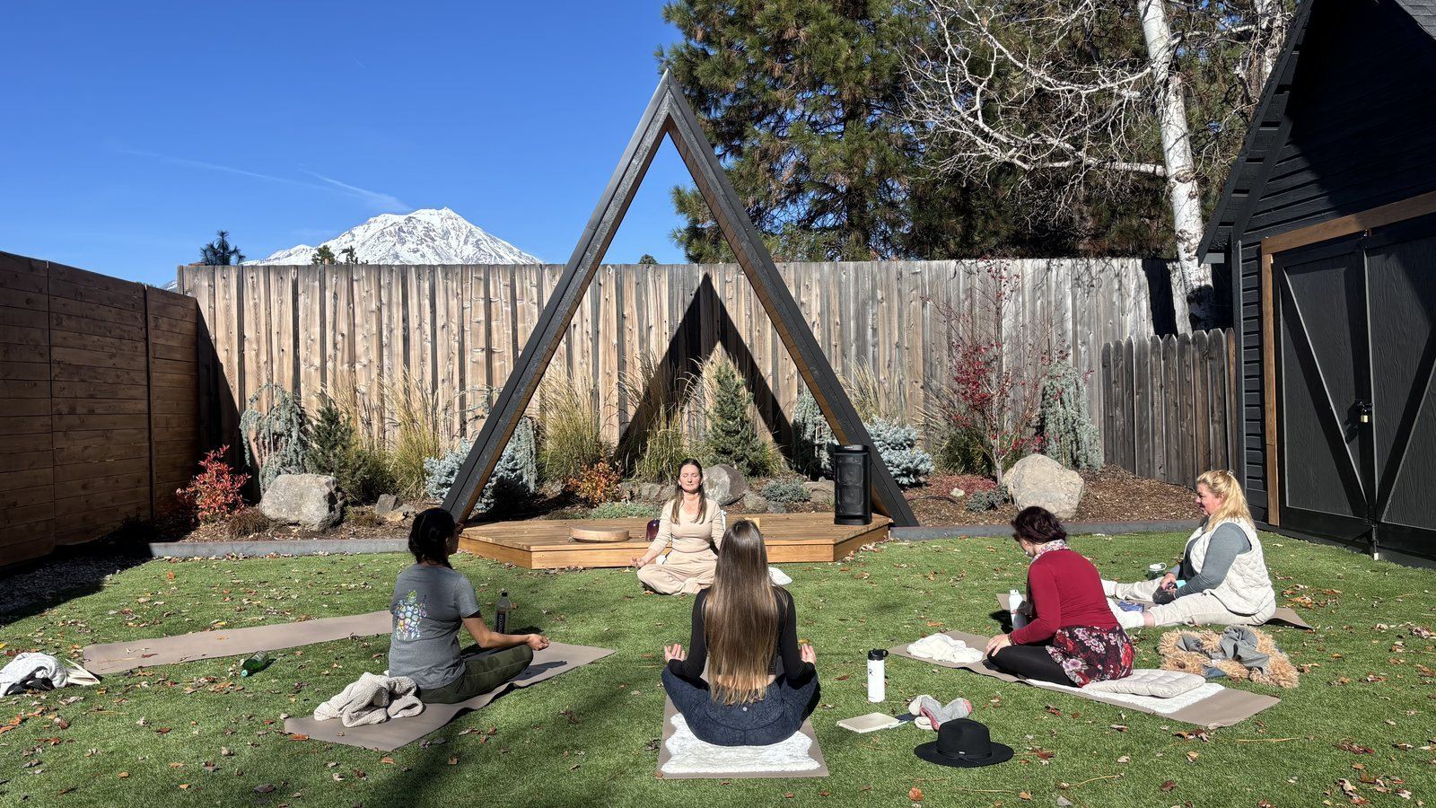 A small circle gathered on the grass for ceremony beneath an open shelter
