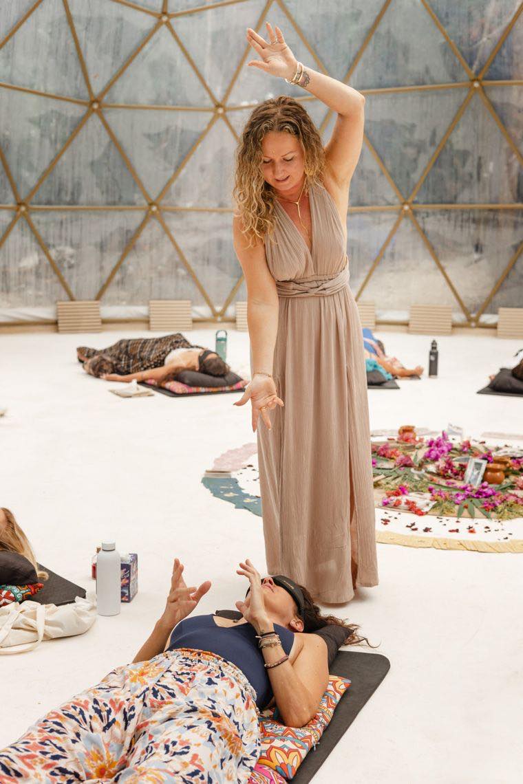 Anya Dillon guiding a Kundalini Activation as a guest lying on her mat raises her hands