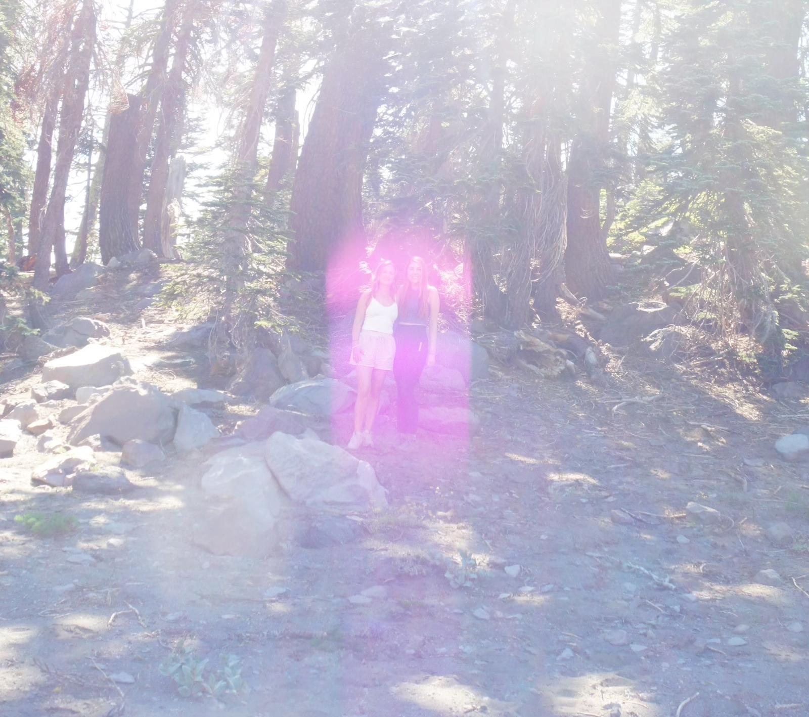 A column of violet light appearing among the trees on the mountain